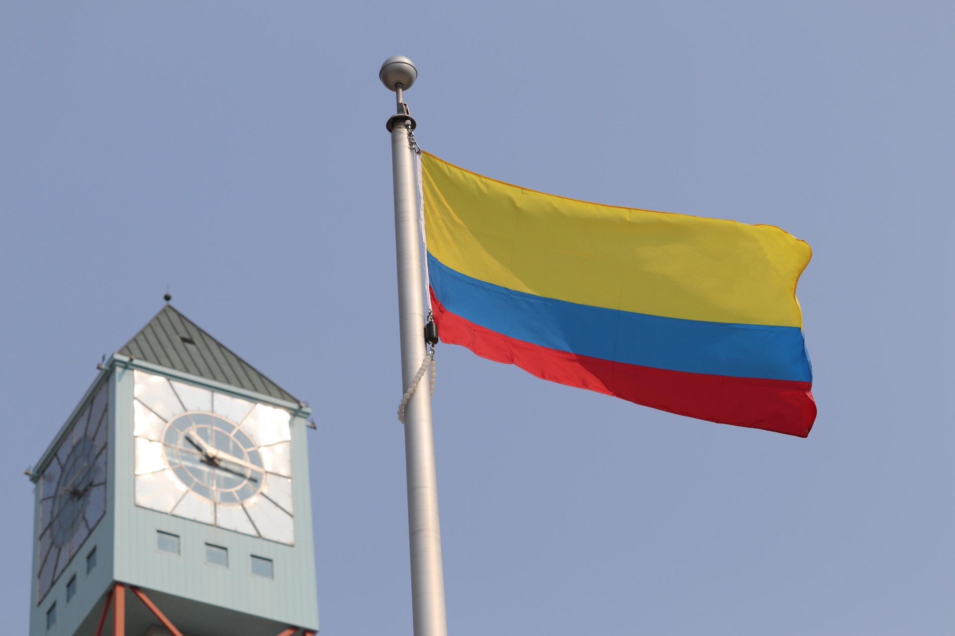 The National flag of Colombia flying in front of the Civic Centre clock tower.